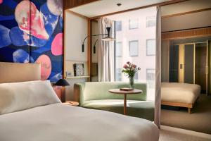 伦敦The BoTree - Preferred Hotels and Resorts的一间卧室配有一张床、一把椅子和一张桌子
