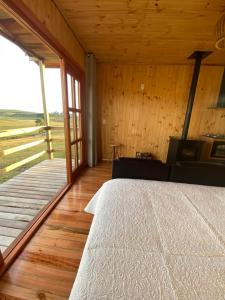 圣若泽-杜斯奥森蒂斯Chalé Campos Da Serra的一间卧室配有一张床,铺有木地板