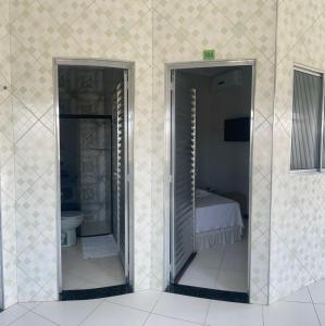 北茹阿泽鲁Hotel Shalom的两扇门位于带床和浴室的客房内