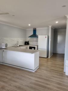 金格罗伊Markwell St Villas的白色的厨房配有水槽和冰箱
