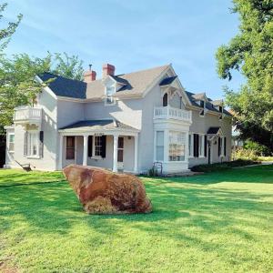 卡纳布The Mayor's Suite @ The Historic Kanab Inn的坐在房子前面的大石头