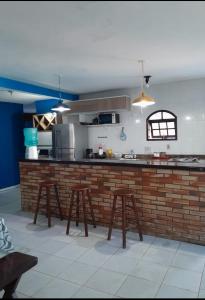 萨夸雷马Excelente casa em Saquarema a 100 passos do mar的厨房配有带凳子的柜台