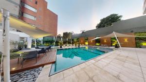 危地马拉Adriatika Hotel & Residence的一座带桌椅的游泳池以及一座建筑