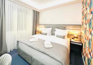 萨拉热窝Apartments Museum的酒店客房带一张大床,上面有两条毛巾