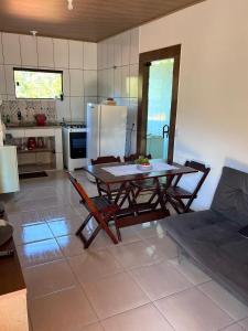 卢米亚Casa Lumiar的厨房配有桌椅和冰箱。