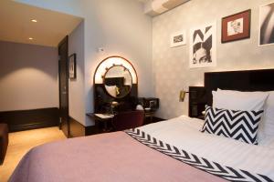 斯德哥尔摩斯堪达干草市场酒店的一间卧室配有一张床、镜子和一张书桌