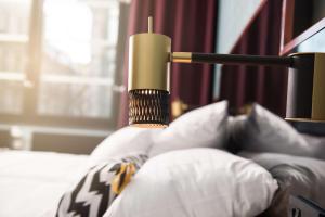 斯德哥尔摩斯堪达干草市场酒店的床上的蜡烛和枕头