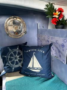昂蒂布Séjour sur voilier的枕头,上面有帆船,旁边是时钟