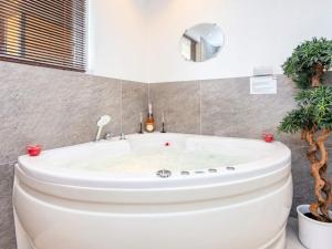 猎枪海滩7 person holiday home in Knebel的浴室设有白色浴缸,种植了植物。