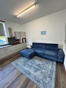 亚历山德里亚Ben Lomond Apartment的一间带蓝色沙发的客厅和一间厨房