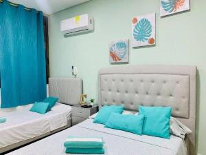 圣玛尔塔Apartamento Samaria Club Resort的卧室内的两张床和蓝色枕头