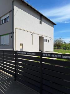 武科瓦尔Holiday house with a parking space Vukovar, Slavonija - 22809的前面有黑色围栏的白色房子