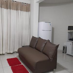 伊帕廷加Apartamento Inteiro Iguaçu Ipatinga的客厅配有棕色沙发,配有冰箱