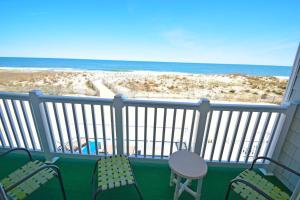 大洋城Ocean Club 4011 townhouse的一个带椅子的阳台,享有海滩美景