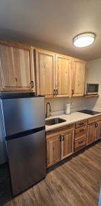 Eagle RiverEagle River Lodge的厨房配有冰箱和木制橱柜。