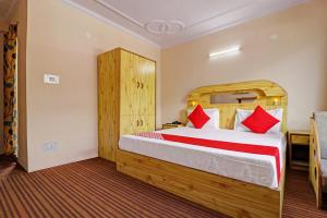 马拉里OYO Flagship Aman Cottage的一间卧室配有一张带红色枕头的大床