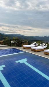 MarquetaliaHotel Villa Del Sol的游泳池旁设有躺椅