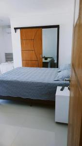 佩尼亚Pousada Família Eleutério的一间卧室配有一张床和一面大镜子