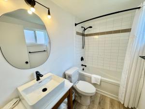 尤克卢利特Ukee Peninsula Motel的一间带水槽、卫生间和镜子的浴室