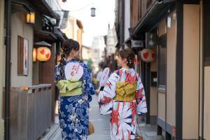 京都OMO5 Kyoto Sanjo by Hoshino Resorts的两个和服上的女人走在街上