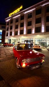 BostanbüküKANYON VADİ HOTEL的停在大楼前的一辆旧红色汽车