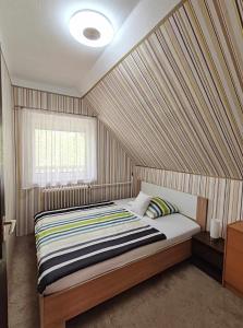 基什孔毛伊绍Csillag Vendégház Kiskunmajsa的一间卧室配有一张带条纹墙的床