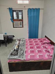 AyodhyaHari Kripa Sadan的一间卧室配有一张床铺,床上铺有粉色毯子