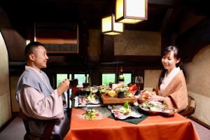 南小国町Satonoyu Waraku 13 years or older的坐在餐桌旁吃饭的男人和女人