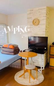 东京平和岛民宿的客房设有书桌和带电视的床铺。