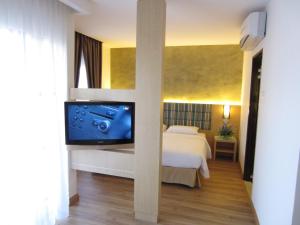 瓜埠Bella Vista Waterfront Resort, Kuah Langkawi的一间卧室配有一张床和一台平面电视