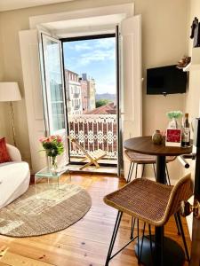 里斯本Stylish City Apartment - Top Stay!的客厅设有桌子和大窗户