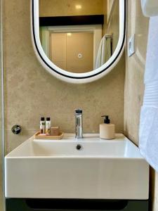 里斯本Stylish City Apartment - Top Stay!的浴室水槽设有大镜子和镜子