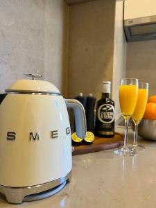 里斯本Stylish City Apartment - Top Stay!的厨房柜台配有榨汁机和2杯橙汁