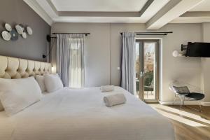 干尼亚Nival Luxury Suites的一间带一张白色大床的卧室和一个阳台