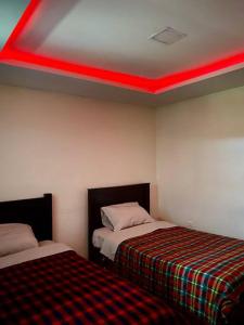 基多Villa Mirlo – Escondite de Lujo en Quito的客房设有两张床和红色天花板。