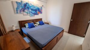 乌斯维塔克伊亚瓦Aqua Vista的一间卧室配有一张带蓝色床单和蓝色枕头的床。