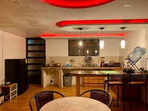 基多Villa Mirlo – Escondite de Lujo en Quito的厨房配有桌椅和红色天花板