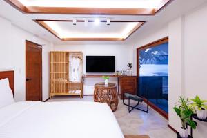 爱妮岛Morgan Villas的一间卧室配有一张床和一台平面电视
