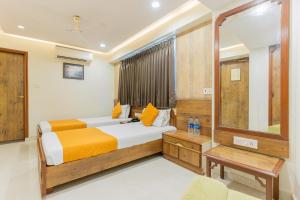 艾哈迈达巴德北京华侨大厦酒店的一间卧室配有一张床和镜子