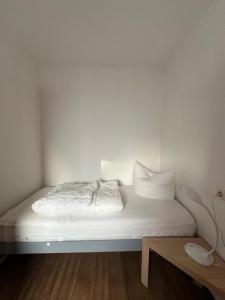 达默Feriengarten Dahme W 15的一张带白色床单和枕头的床