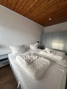 达默Feriengarten Dahme W 15的一间卧室配有带白色床单和枕头的床。