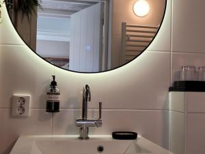 海边的艾格蒙特Tiny Villa de Haas met Infraroodsauna的一间带水槽和镜子的浴室