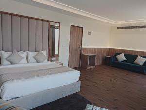 斋浦尔Cilantro Comfort Jaipur的酒店客房设有一张大床和一张沙发。