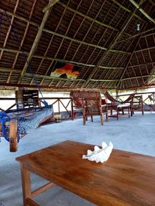 米查维Karibu Paradaizi的客房设有几张床和一张木桌
