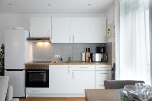 魏尔堡Gemütliches Apartment erstes OG NEU的厨房配有白色橱柜和炉灶烤箱。