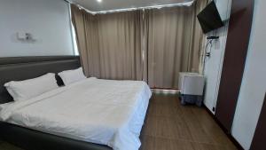 Ban Tha MakGreen Country Park Resort的卧室配有白色的床和电视。