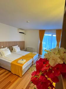 佩斯塔尼Villa Pestani的酒店客房,设有两张床和红色鲜花