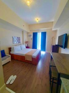宿务Arlowes Cebu at 20f Grand Residences Cebu的酒店客房,配有床和电视