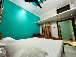 AyodhyaSainik Homestay, Ayodhya的一间卧室配有一张蓝色墙壁的床