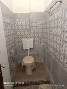 德奥加尔Kailash home的一间带卫生间和瓷砖墙的浴室